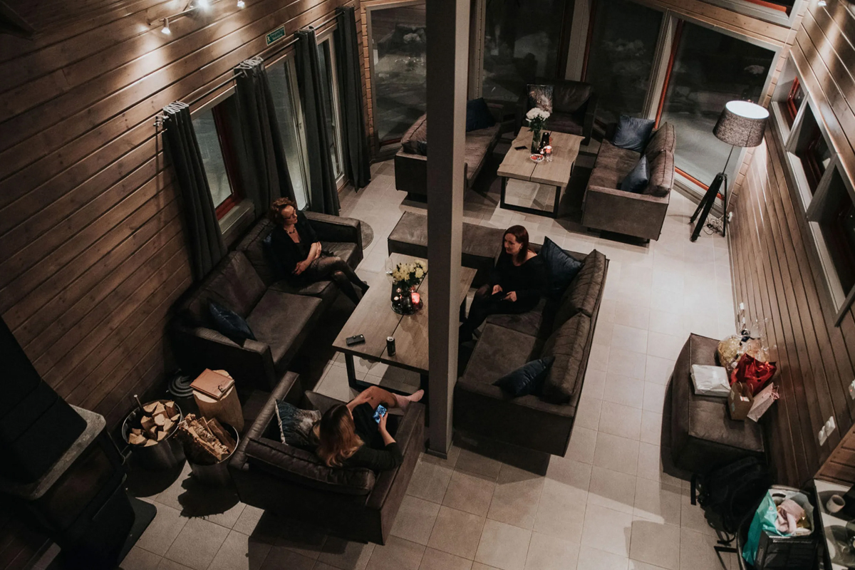 Guests relax in the main cabin lounge at Alten Lodge in the evening.