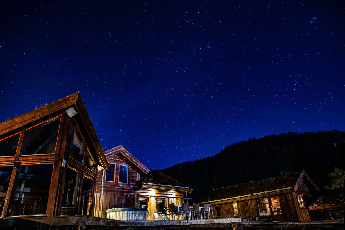 Alten Lodge glowing at night under a clear starry sky.