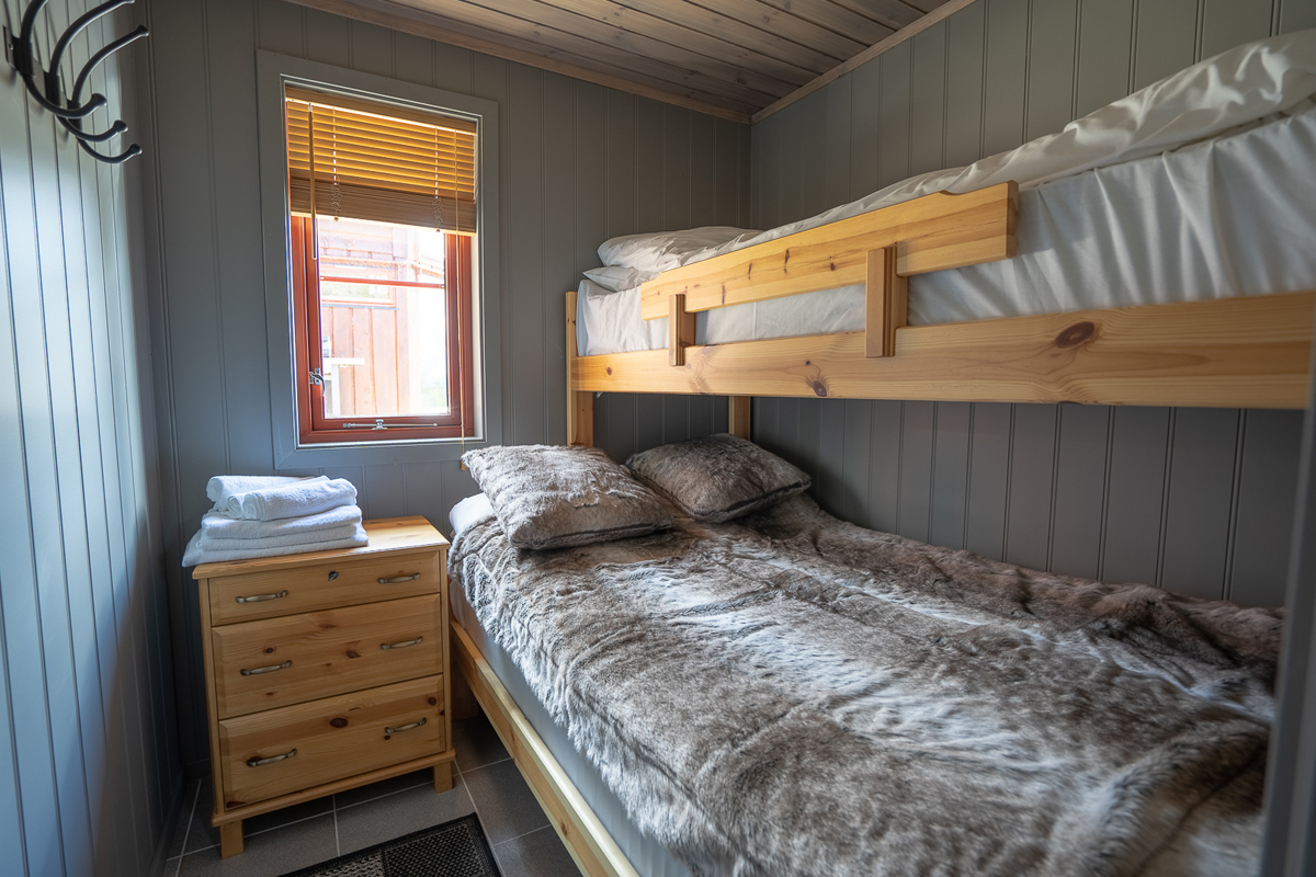 Bunk bedroom in a small cabin at Alten Lodge with fresh towels on the nightstand.