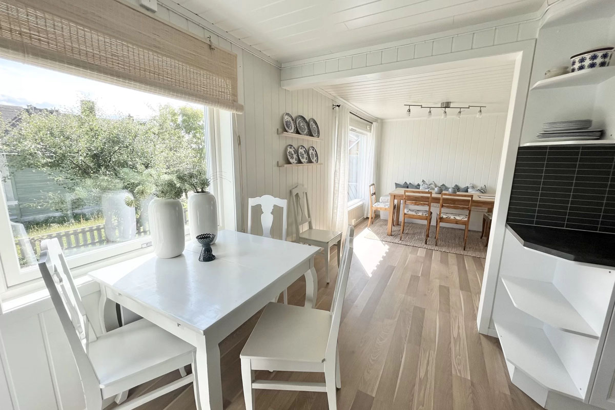 White dining room with garden view in a renovated self-catering house in Bugøynes