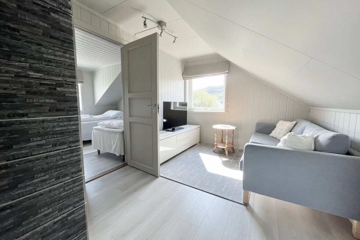Attic lounge with TV and sofa in a self-catering house at Varanger Brygge Bugøynes