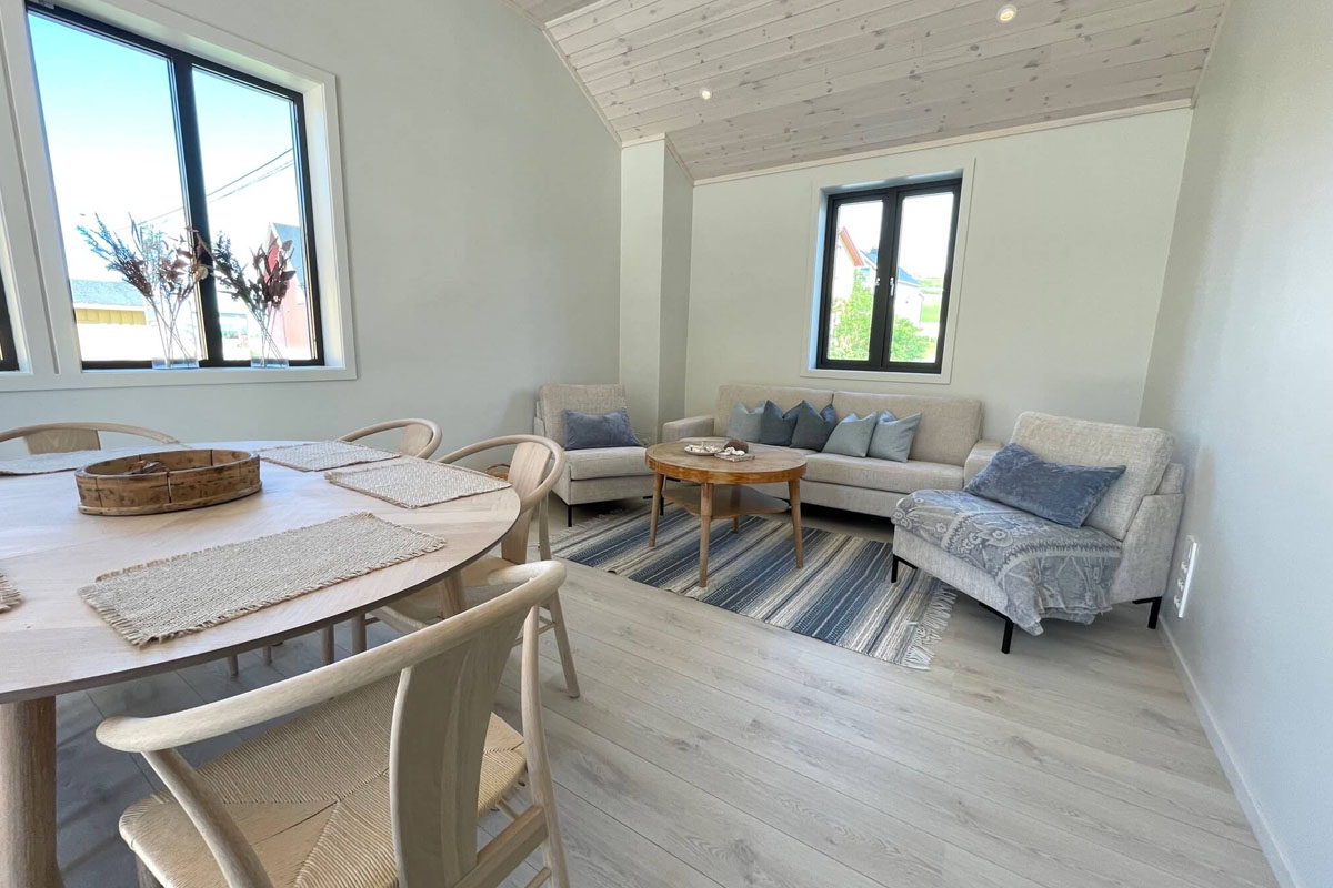 Light-filled living and dining room with wooden ceiling in a Varanger Brygge house in Bugøynes