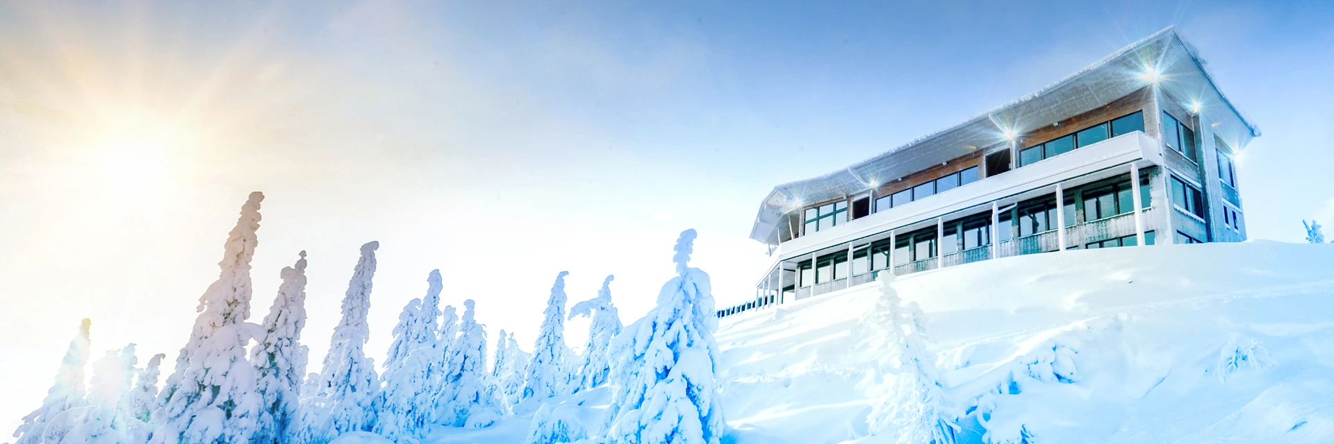 Vue extérieure de l’hôtel Iso Syöte en Laponie au sommet d’une colline couverte de neige épaisse
