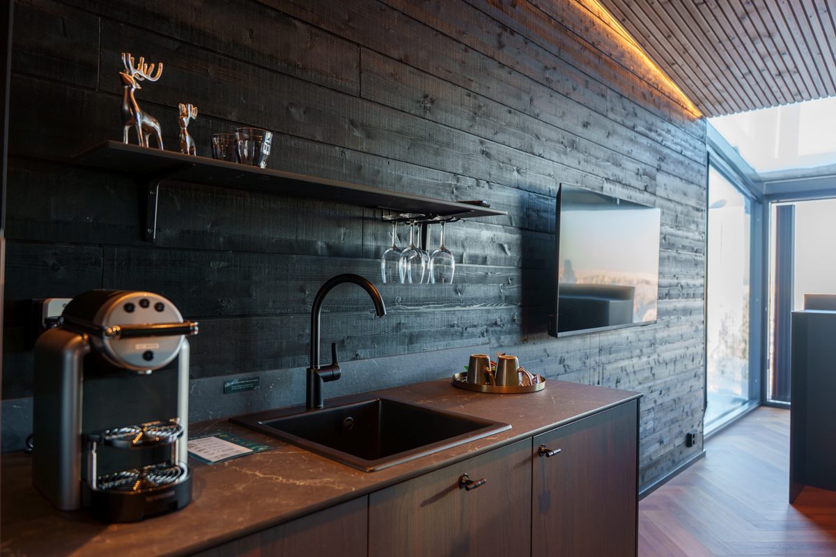 Kitchenette inside an Aurora Room at Lumo Resort in Ruka, with dark wood finishes.
