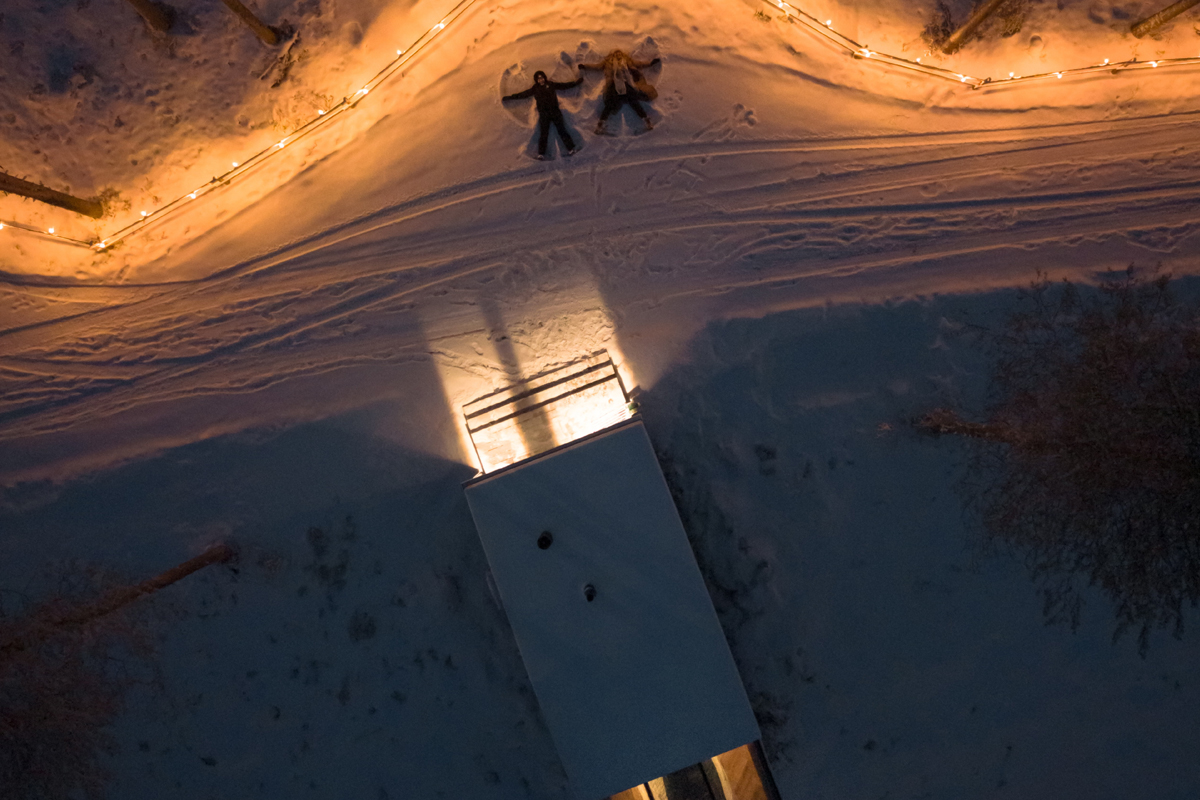 Aerial view of guests making snow angels outside an Aurora Room at Lumo Resort, Ruka.