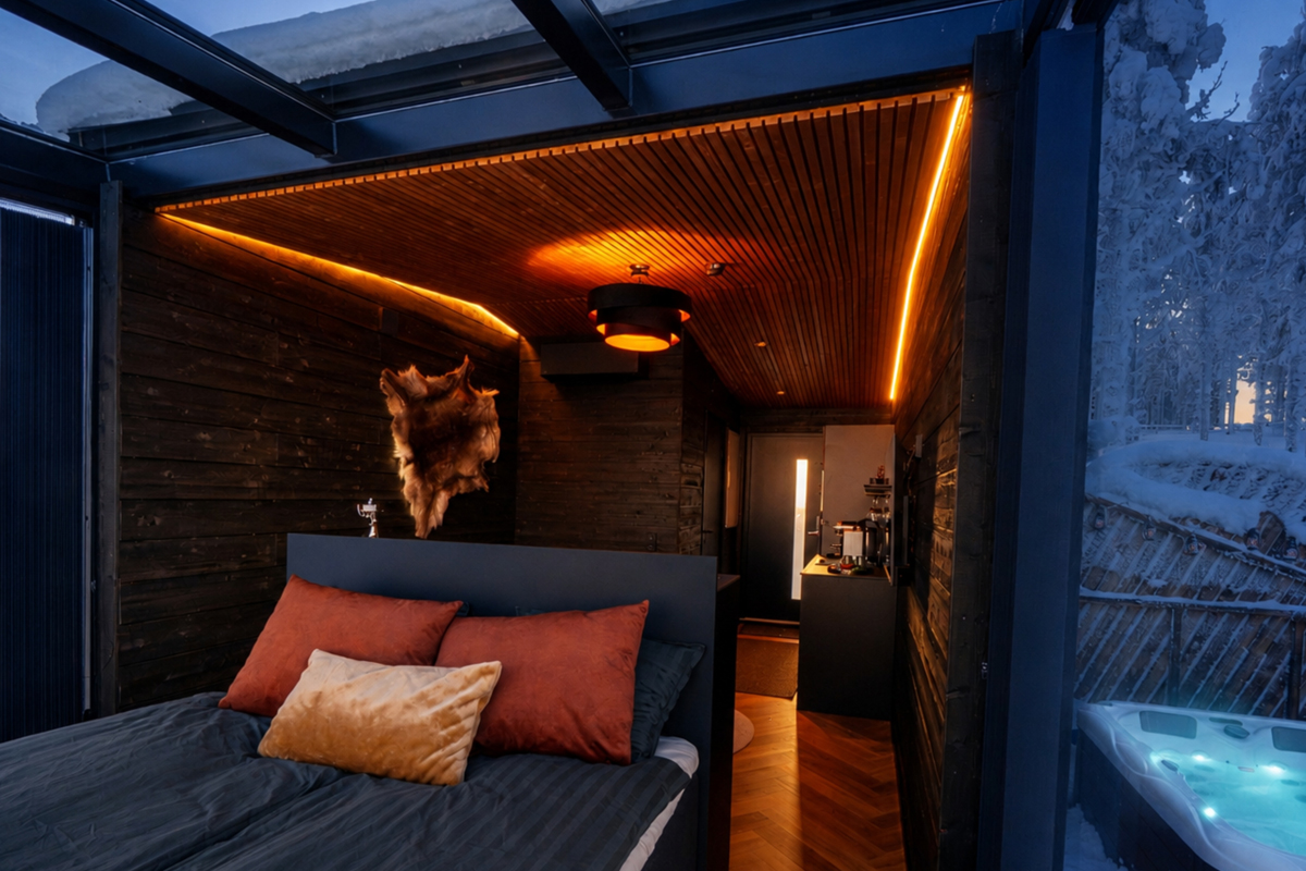 Bedroom inside an Aurora Spa Room at Lumo Resort in Ruka, with hot tub visible outside.