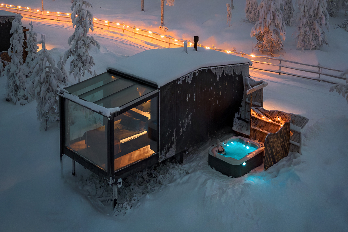 Aurora Spa Room at Lumo Resort in Ruka, glass fronted with outdoor hot tub at dusk.