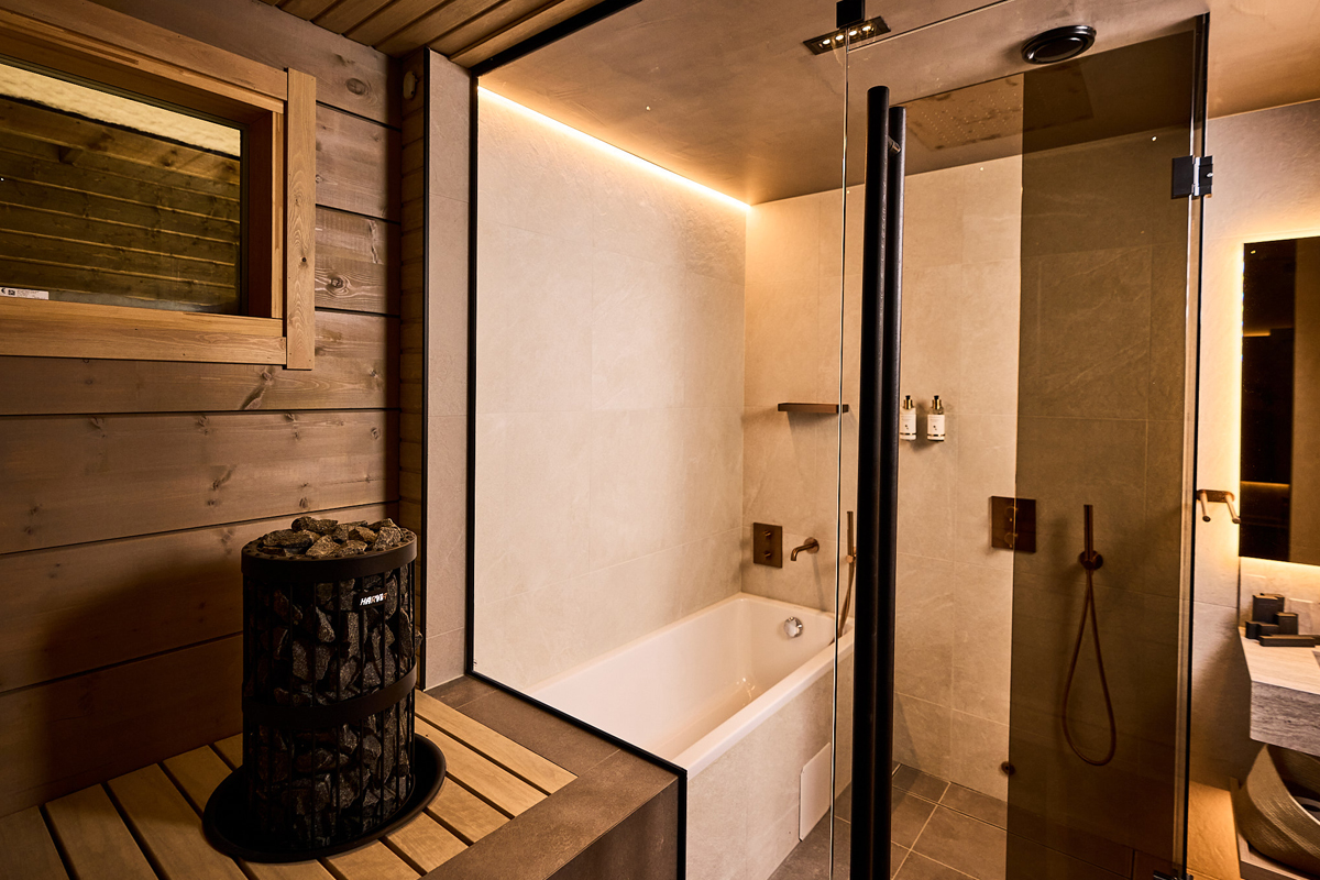 Bathroom with sauna at Balder Luxury Lodge in Levi, with freestanding tub and rainfall shower.