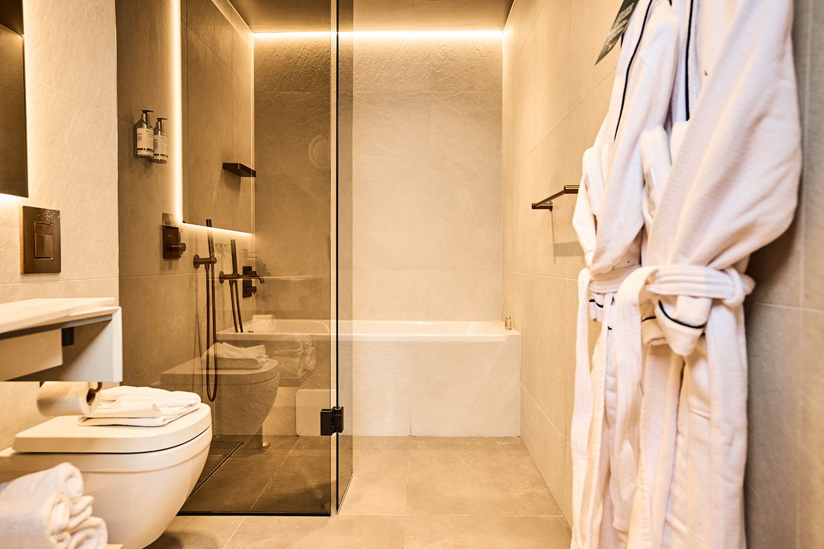 Bathroom at Balder Luxury Lodge in Levi, with soaking tub and bathrobes.