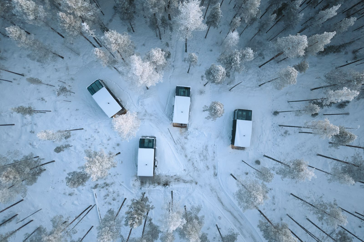 Aerial view of Glass Igloos at Balder Luxury Lodge in Levi, set among frosted pine trees.