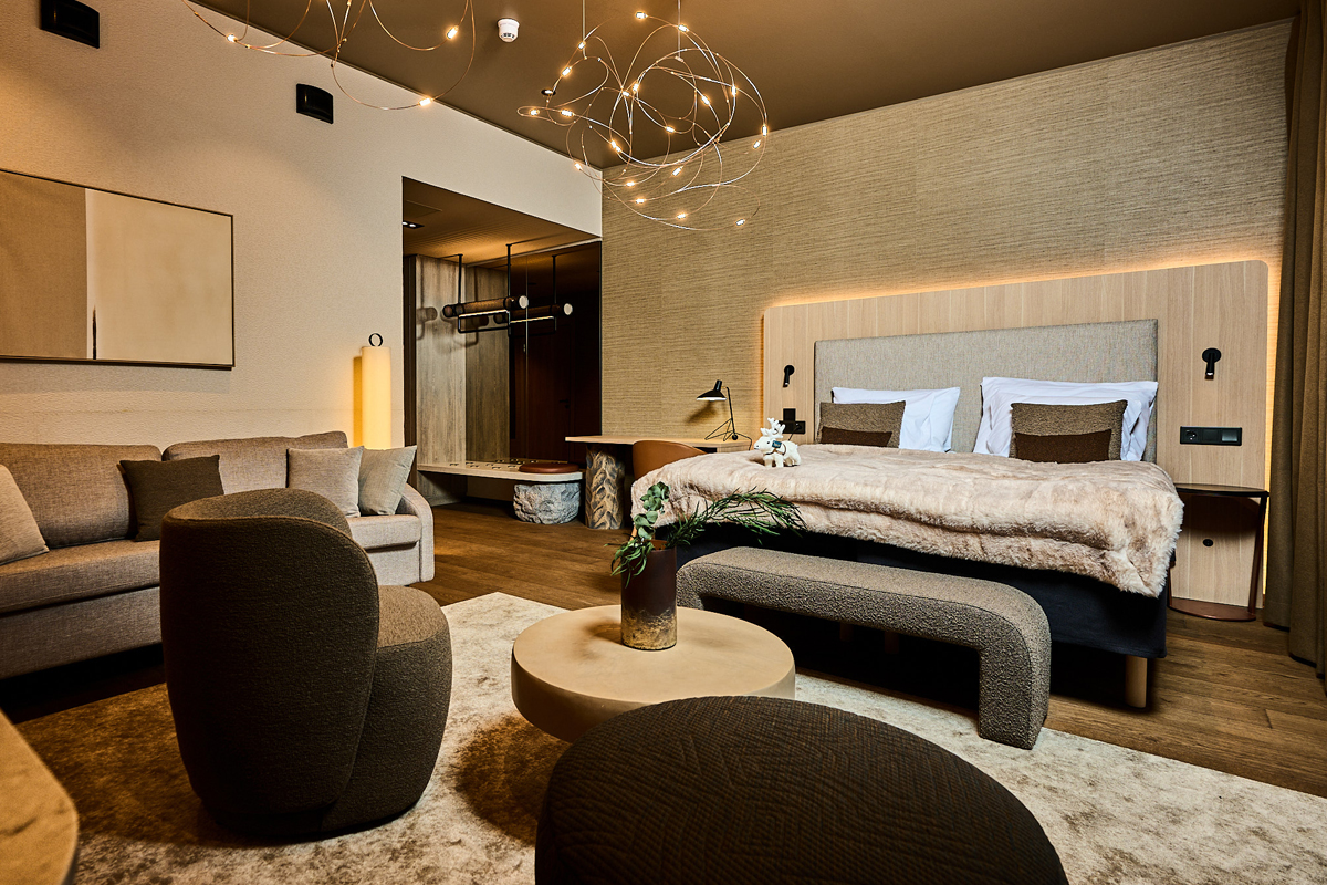 Suite at Balder Luxury Lodge in Levi, with sofa seating and a plush bed.