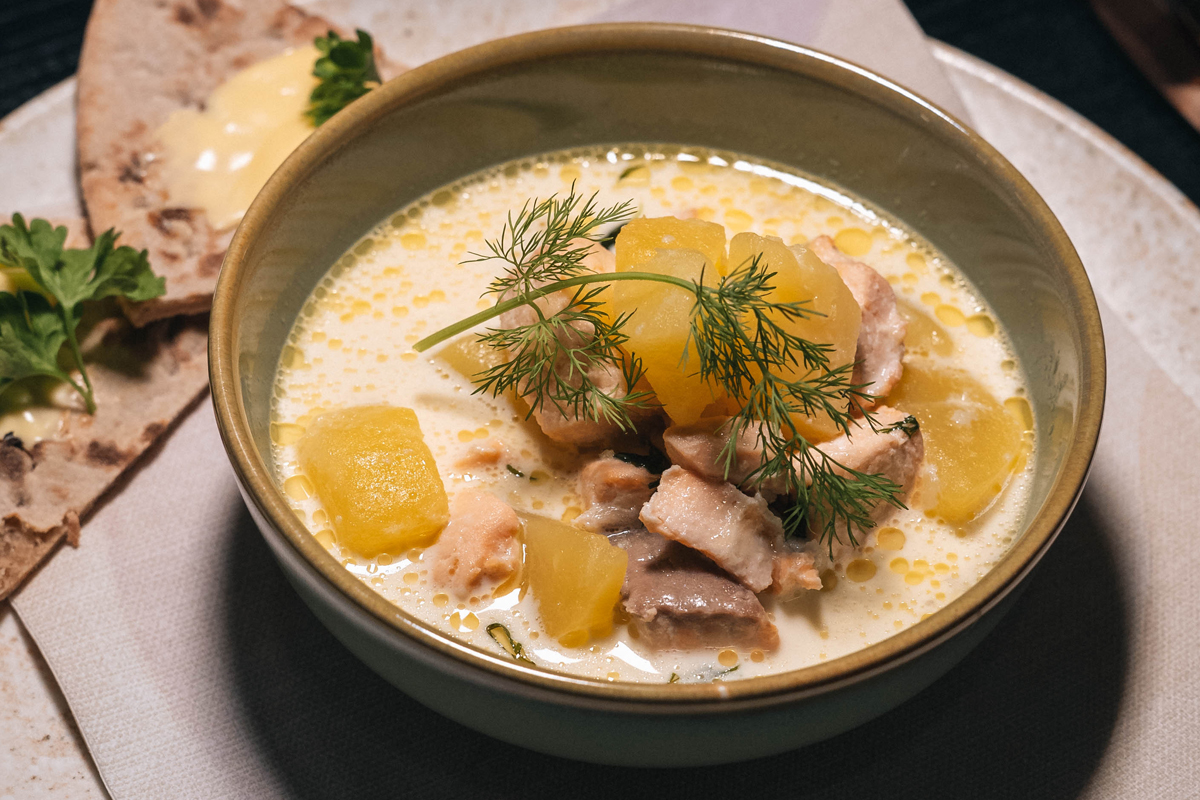 Bowl of creamy Finnish fish soup with potato and dill, served with crispbread, Olo Resort, Levi