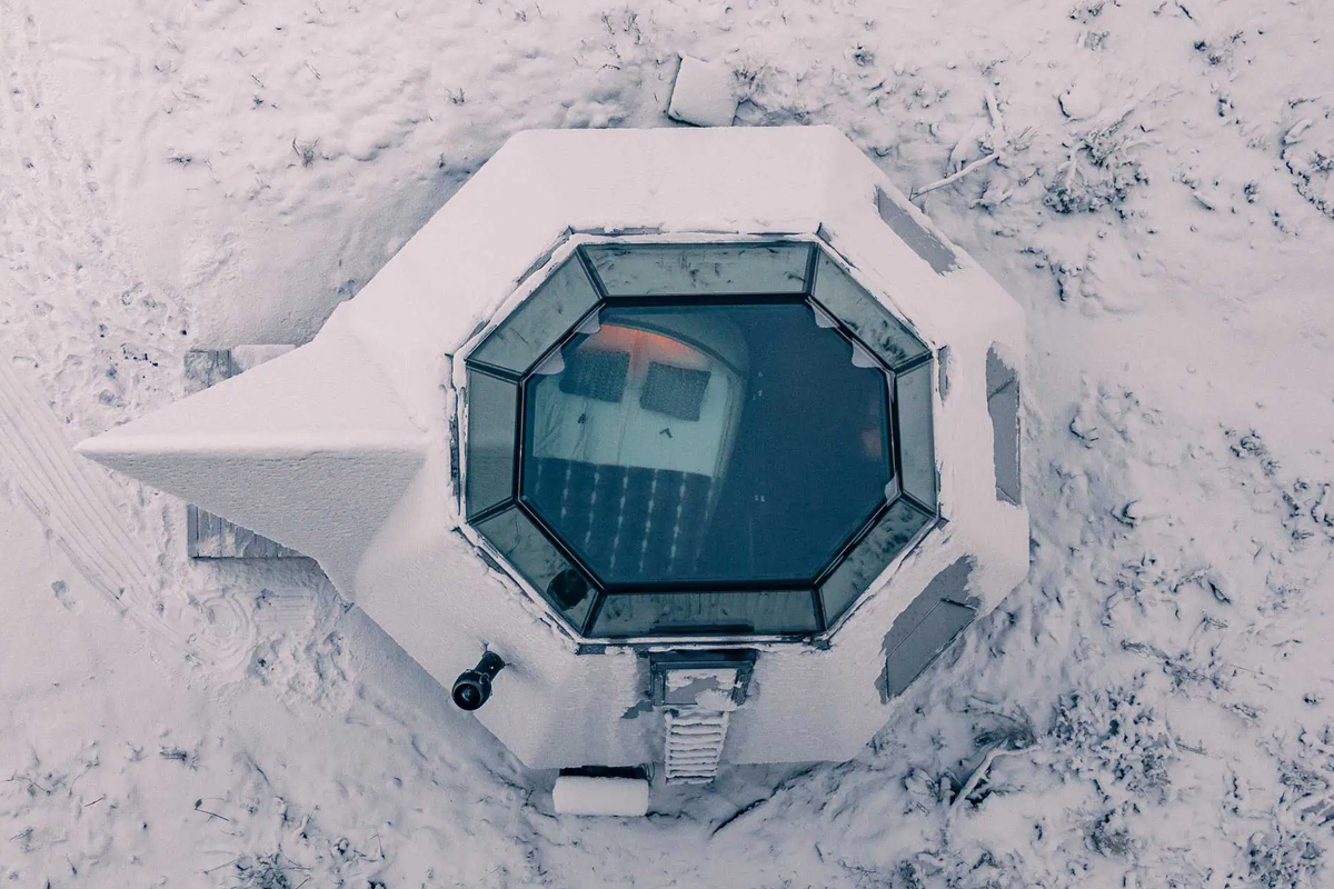 Aerial view of the Komsio Suite's glass roof at Apukka Resort, dusted with snow.