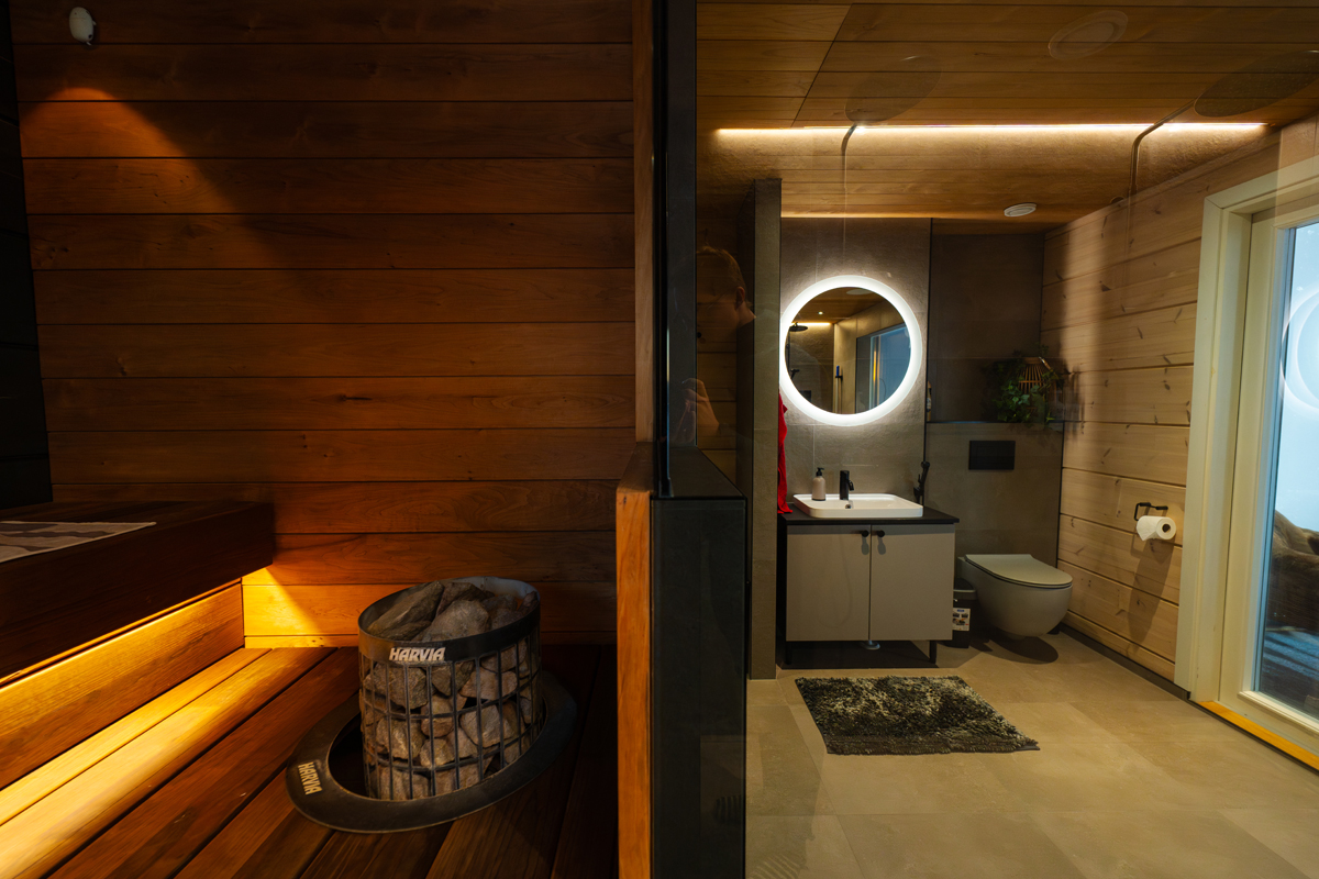 Sauna et salle de bain attenante à la villa, séparés par une paroi vitrée.