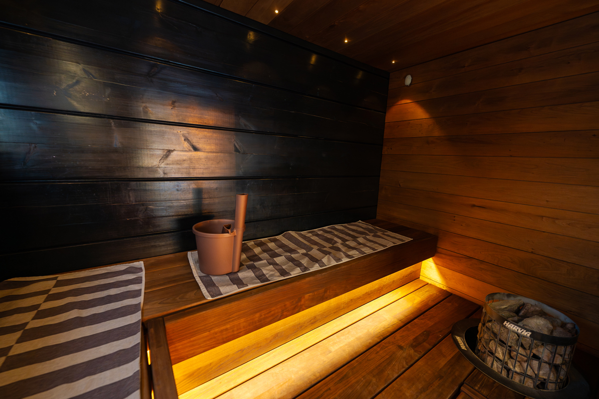 Sauna traditionnel à la villa avec serviettes rayées et poêle Harvia.