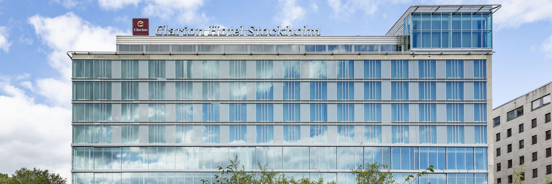 Glass facade of Clarion Hotel Stockholm in Södermalm, with the hotel's rooftop spa structure visible above the building.