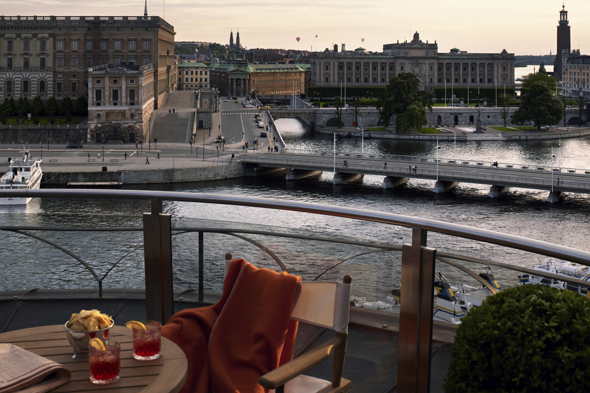 View from a suite terrace at Grand Hôtel Stockholm, overlooking the Royal Palace, Gamla Stan, and the Stockholm waterfront at dusk.
