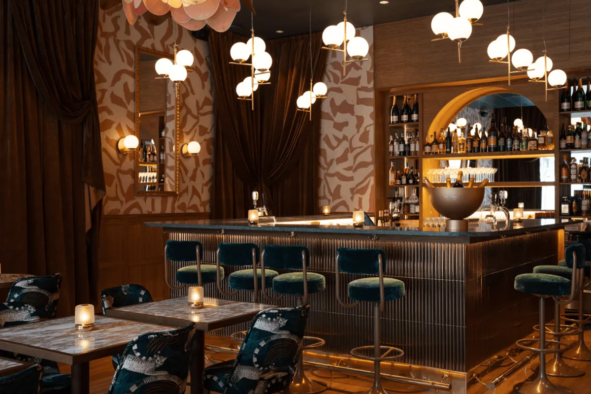 Lounge and bar area at The Sparrow Hotel in Stockholm, with velvet bar stools, globe pendant lights, and warm atmospheric lighting.