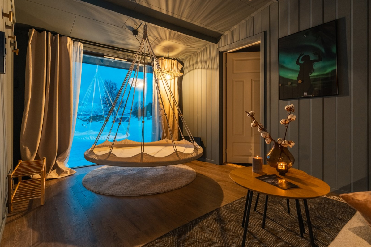 Hanging swing chair inside an Aurora Cabin at Aera in Tromso.