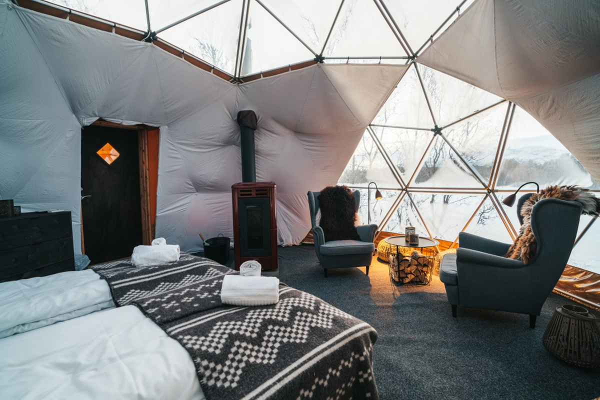 Bed and lounge area inside an Aurora Igloo at Aera in Tromso.