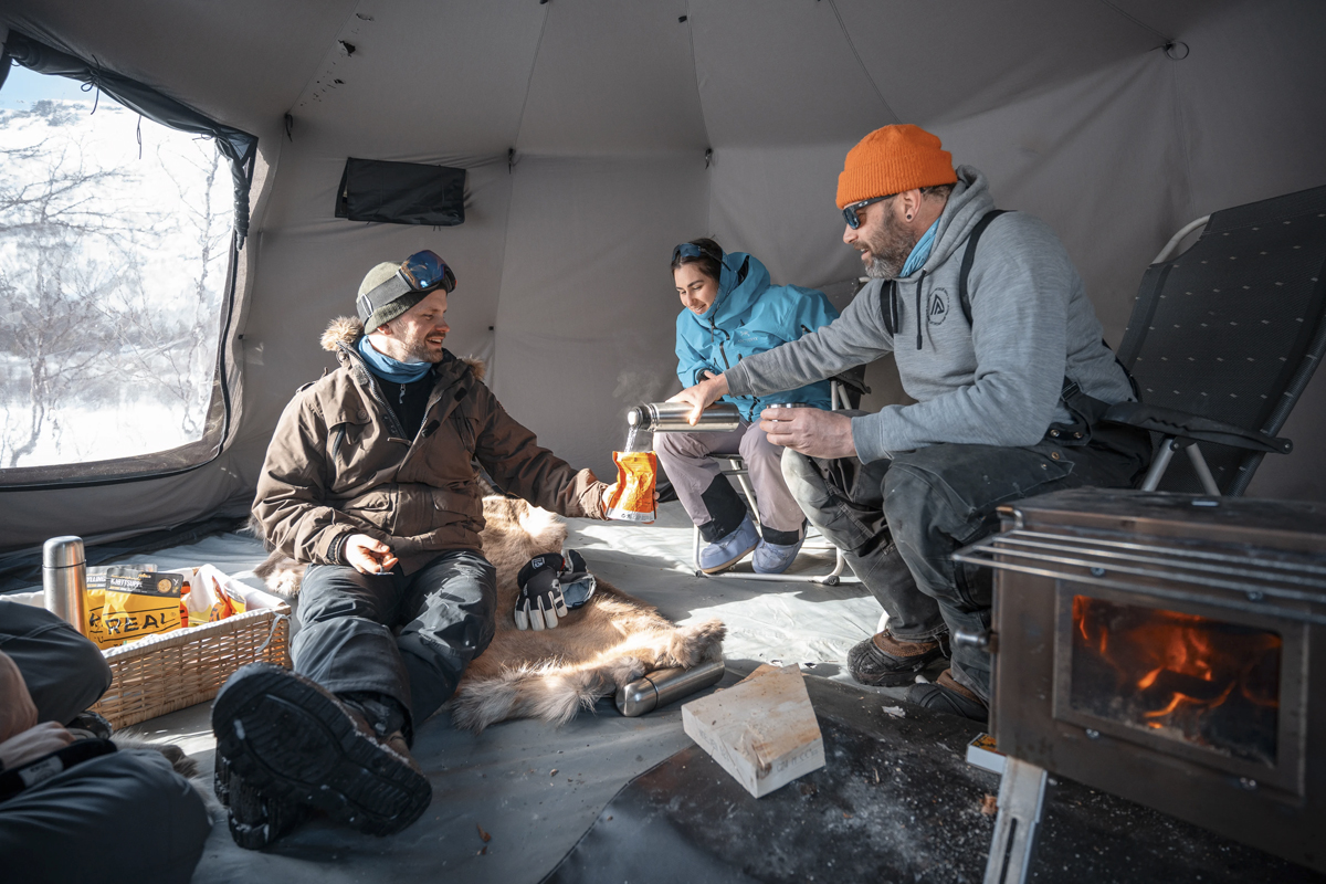Guests warming up inside a heated tent during an outdoor excursion near Aera.
