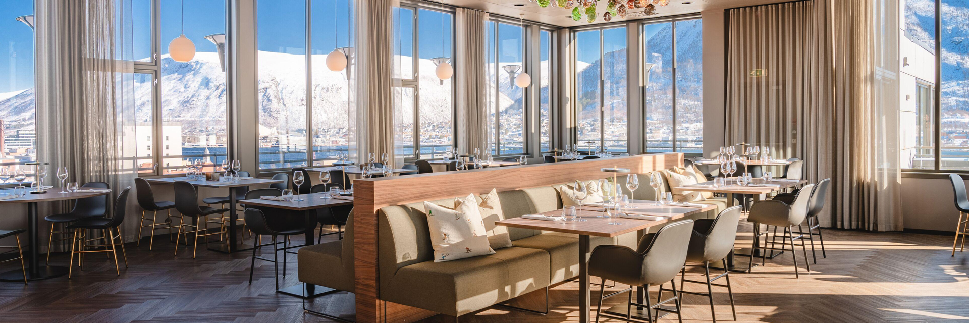 Panoramic restaurant at St. Elisabeth Hotel & Spa in Tromso, surrounded by snow capped mountains.