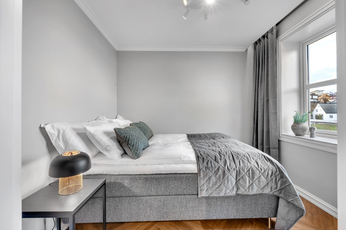 Bedroom at St. Elisabeth Hotel & Spa in Tromso, in soft grey tones with a garden view.