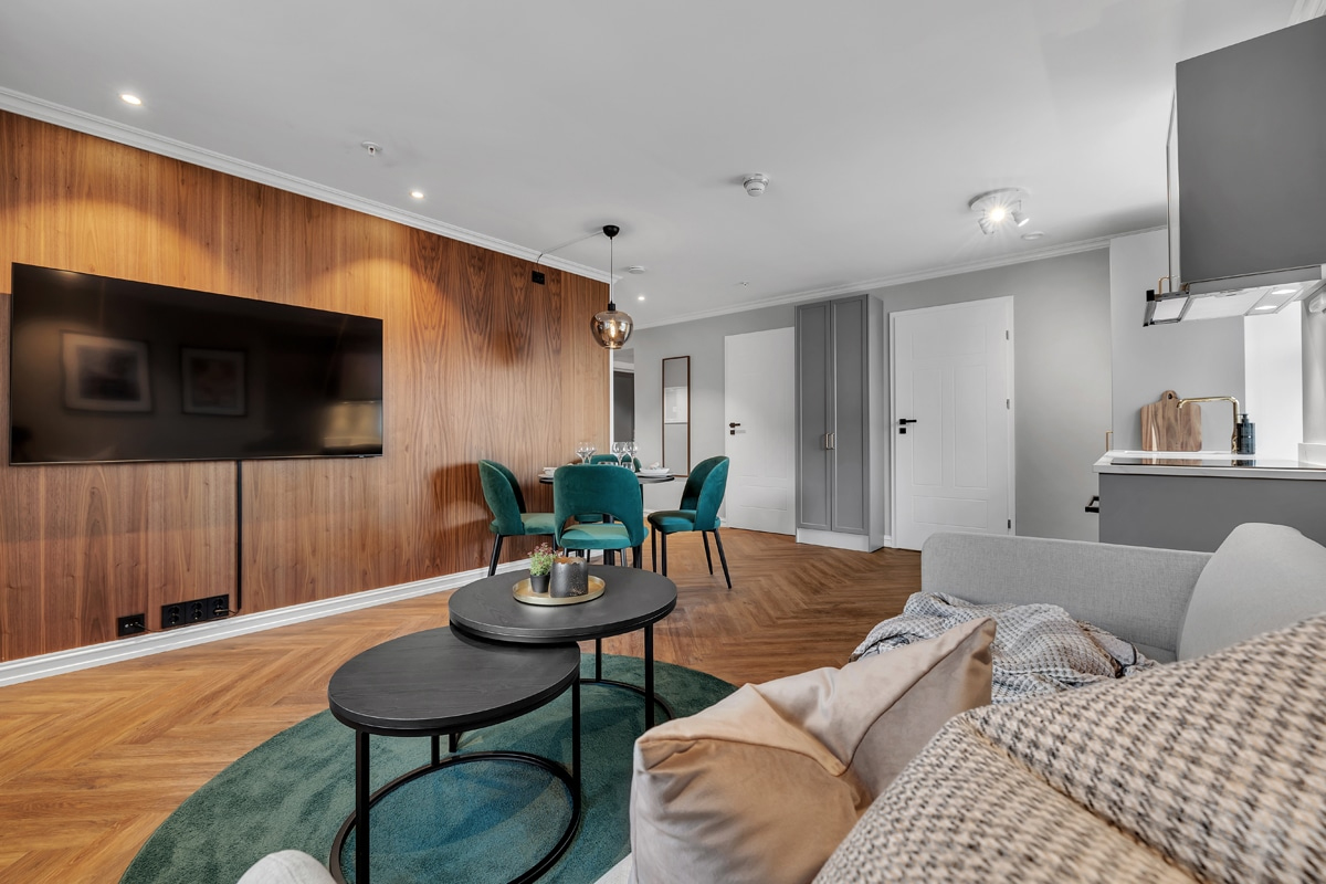 Living and dining area at St. Elisabeth Hotel & Spa in Tromso, with wood paneling and a TV.