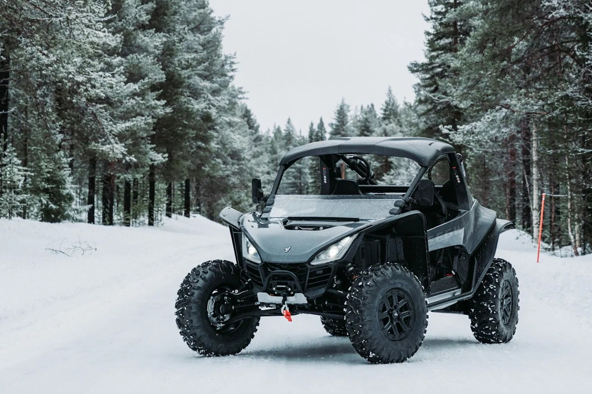 A black ATV buggy parked on a snowy forest trail during a winter ATV tour in Lapland.