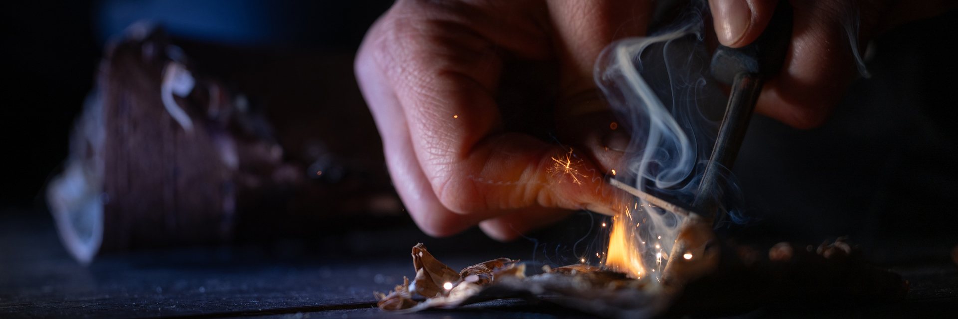 Hands lighting a fire during an arctic bushcraft skills course