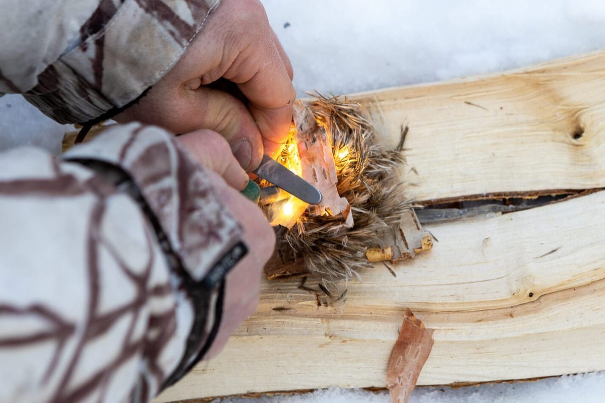 Using a fire starter stick on wood during a bushcraft course in Lapland