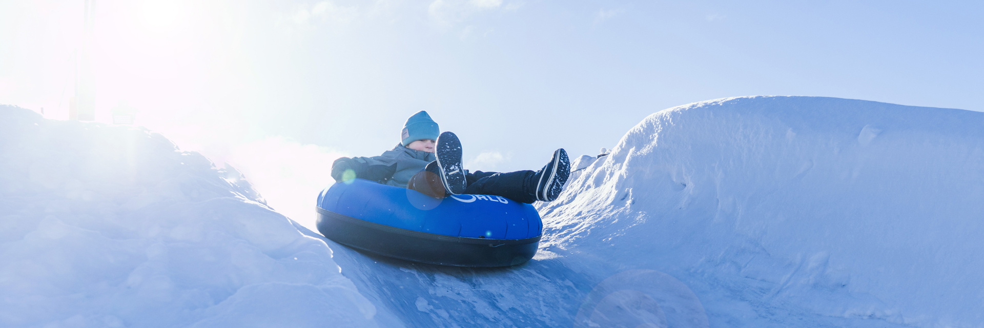 Child sliding down a snow tubing track at Snowman World.