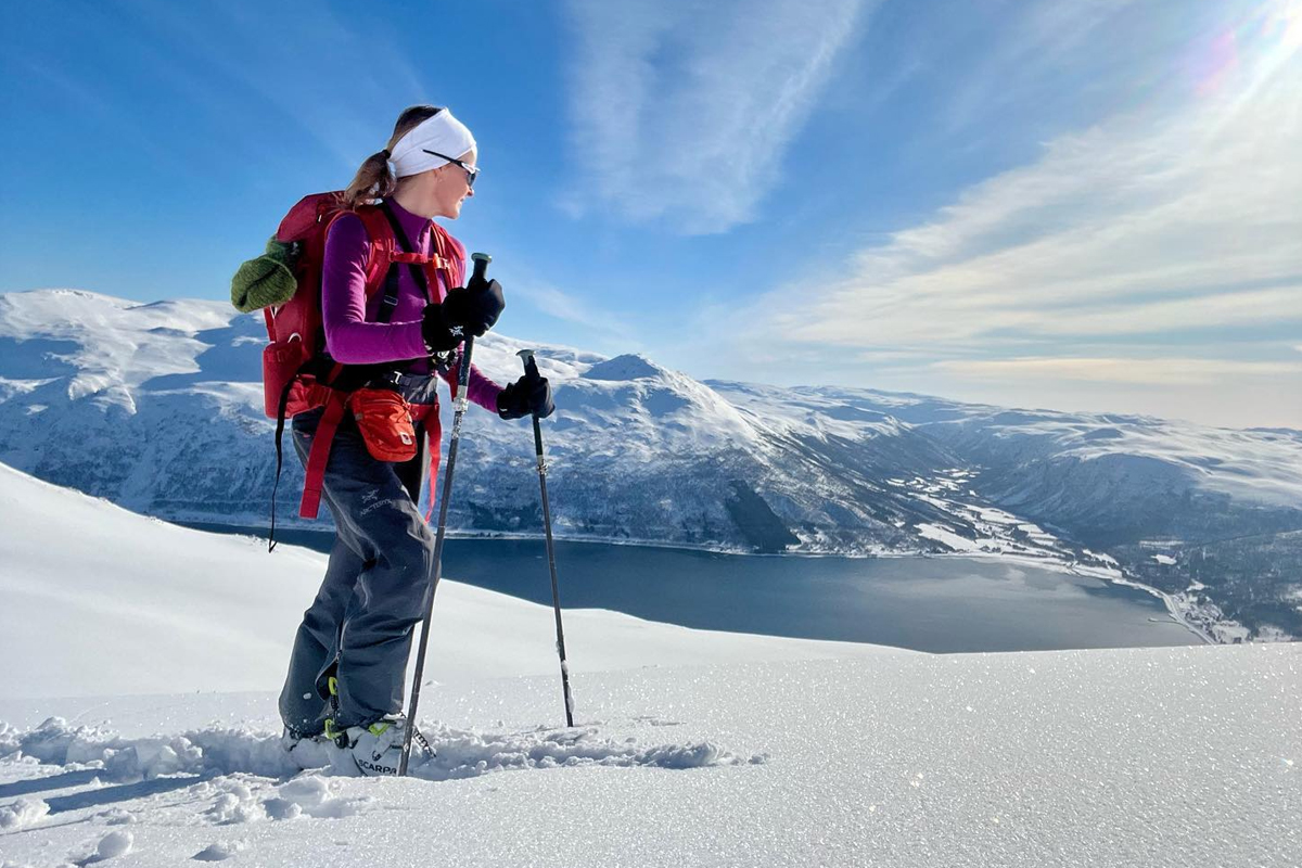 A skier pauses on a mountain ridge overlooking a fjord near Alta, Norway.