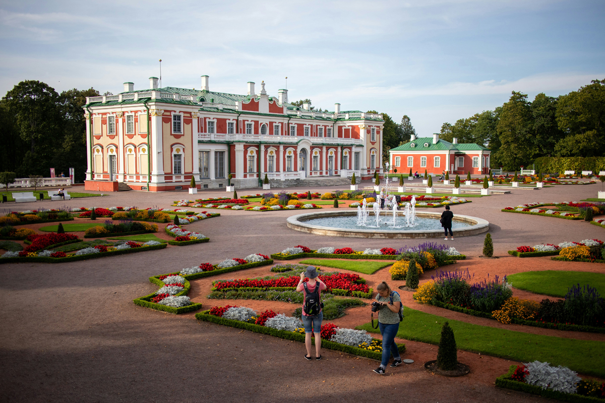 Kadriorg Palace and its formal gardens in summer, with visitors walking among colourful flower beds in Tallinn.