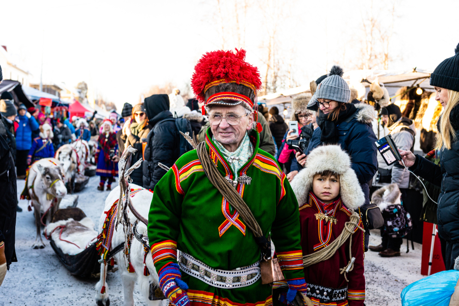 Sami man and child in traditional embroidered costumes at the Jokkmokk Winter Market, Swedish Lapland