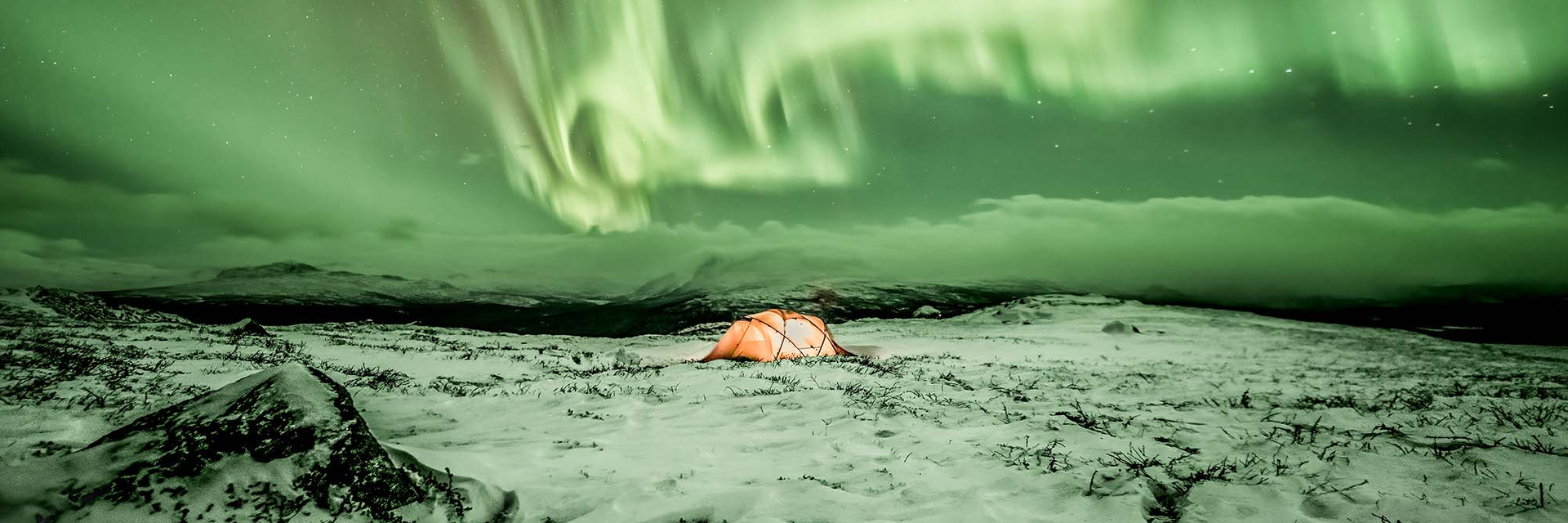 Here are the updated versions with the photo credit included.  EN A lit orange tent on a snow-covered landscape under a vivid northern lights display, Jokkmokk, Swedish Lapland. Photo: Northern Panorama