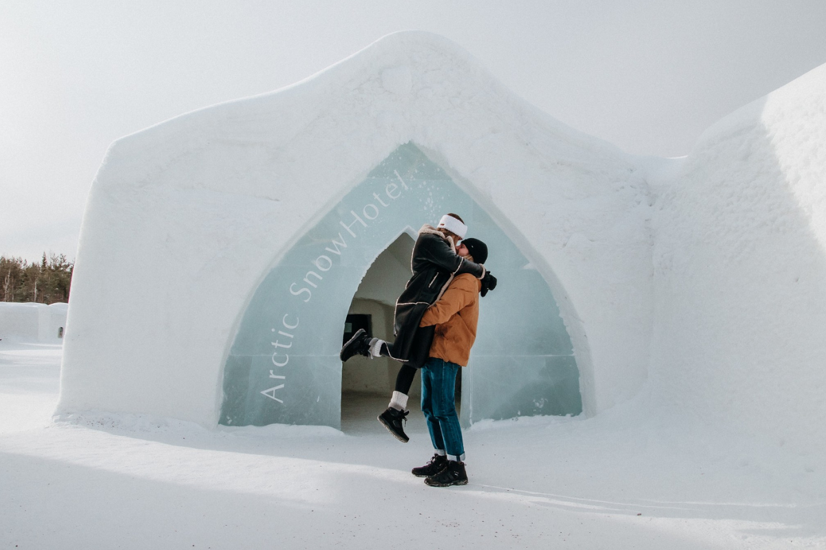 Un couple s'enlaçant à l'entrée de l'Arctic SnowHotel, à Rovaniemi.