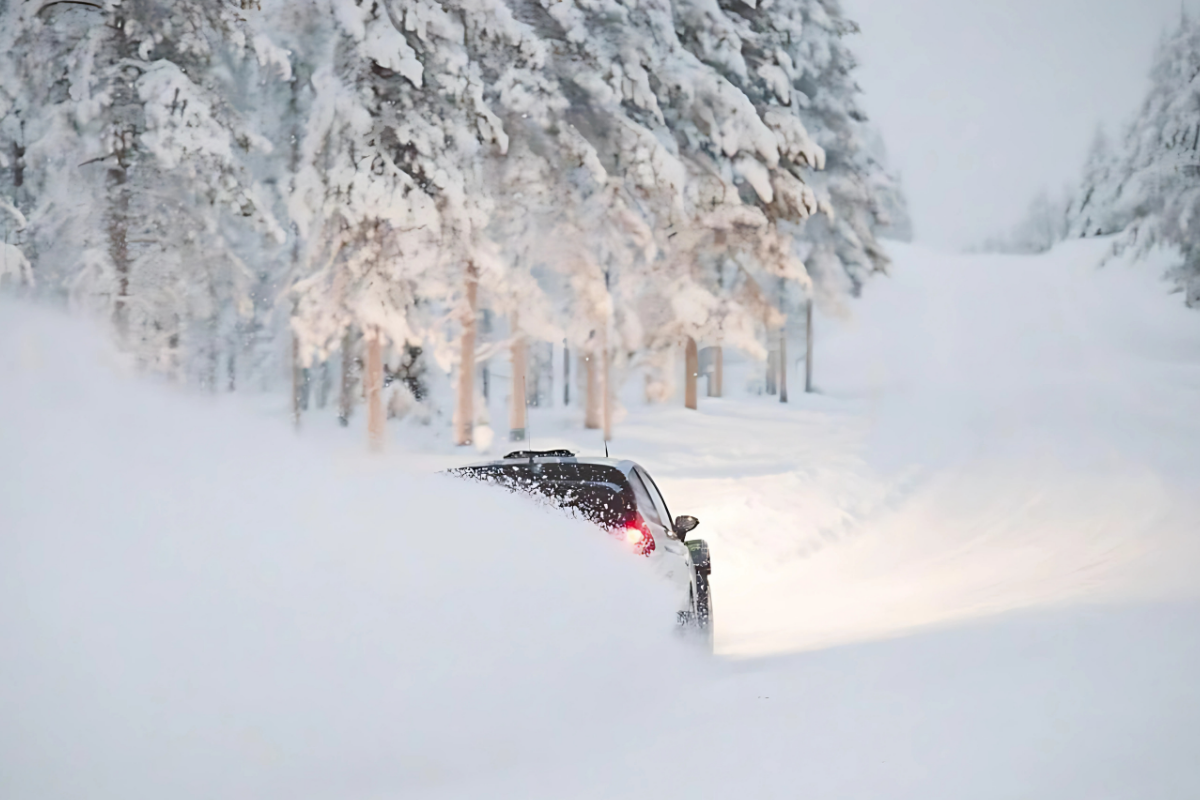 Une voiture glissant dans la neige profonde sur une route forestière, lors d'une conduite sur glace.