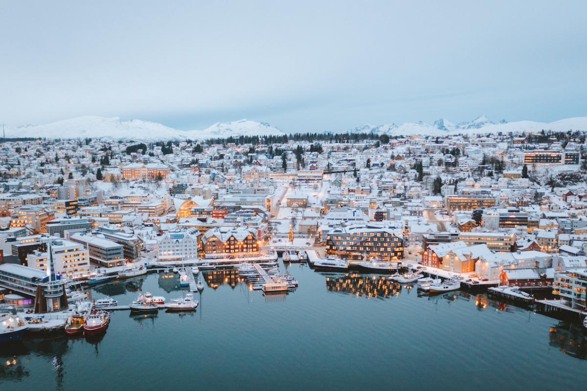 Vue aérienne de Tromsø, en Norvège, avec ses bâtiments enneigés le long du port.