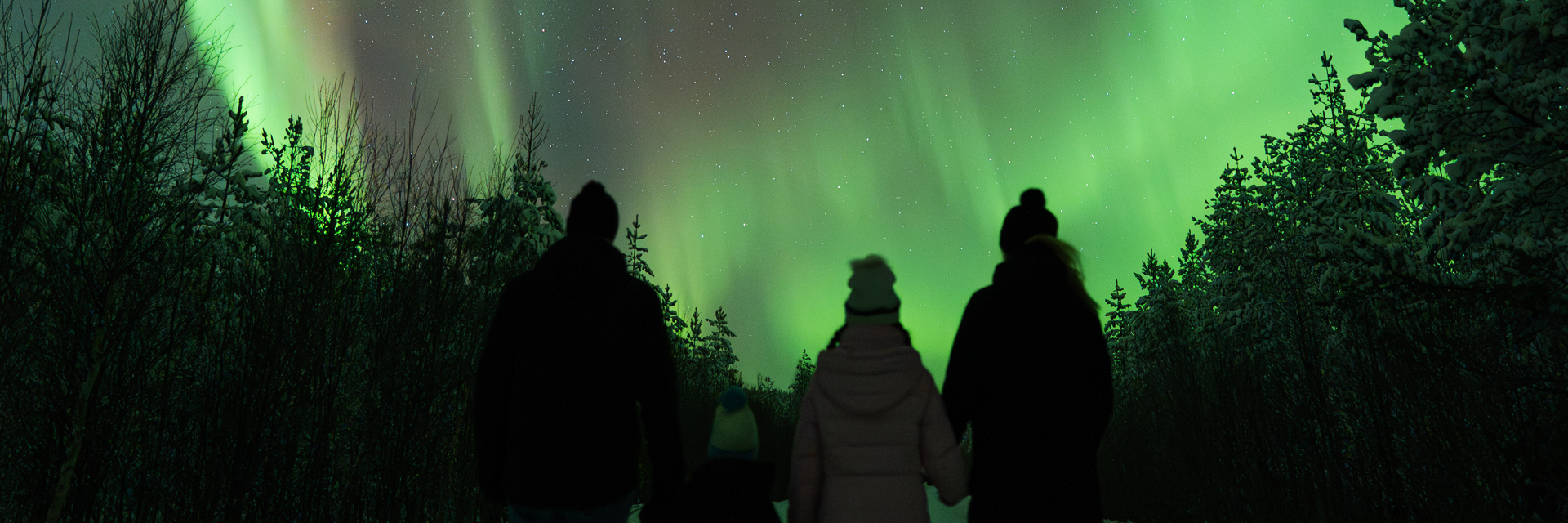 Family watching the northern lights together in Rovaniemi. Photo: Joona.