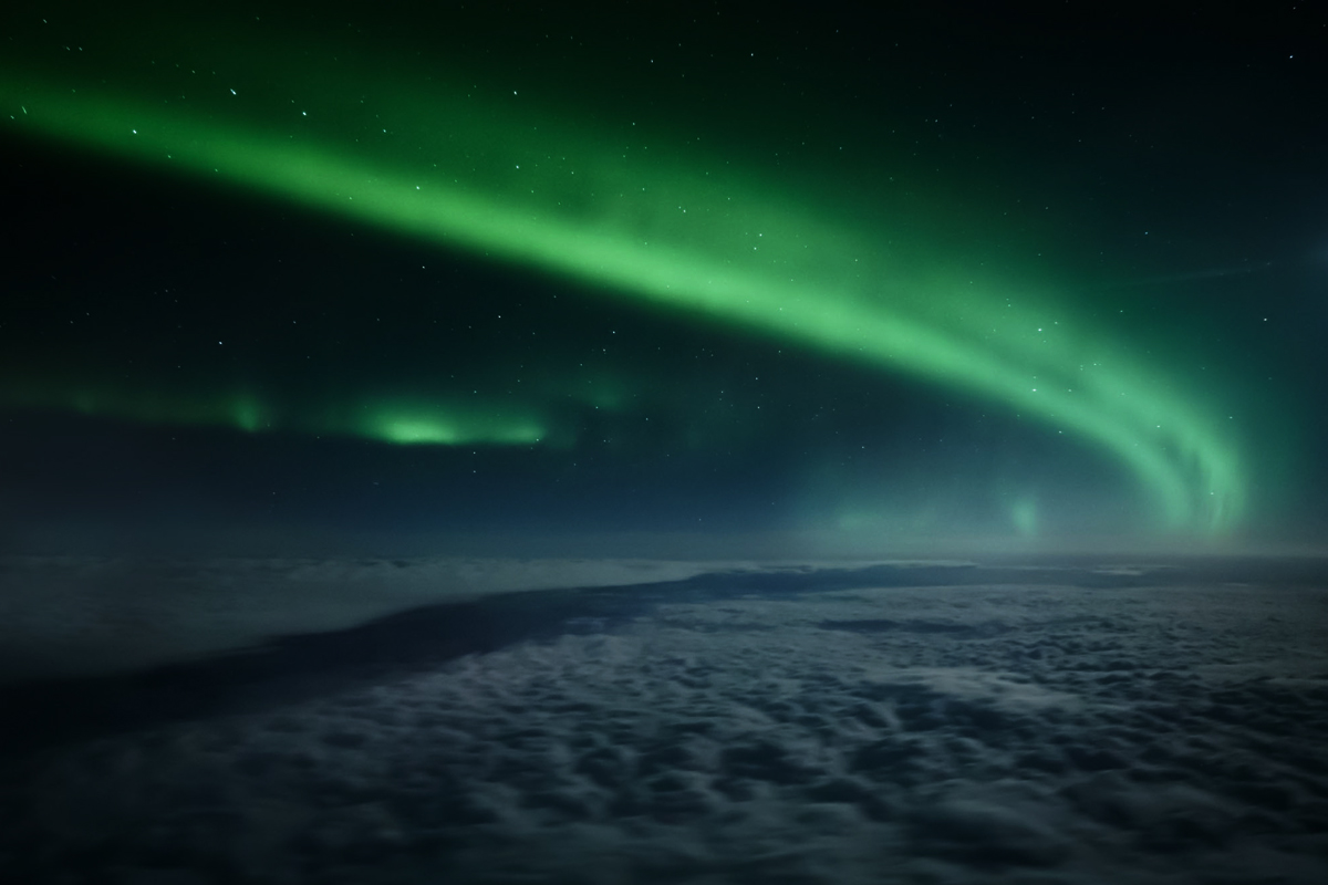 Aurores boréales vues depuis les nuages lors d'un vol privé au-dessus de la Laponie